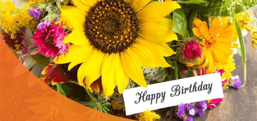 A bunch of flowers with a Happy Birthday greeting card