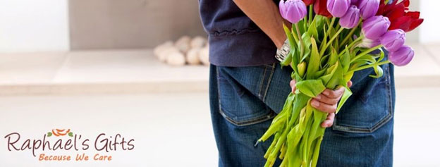 A man holding a bouquet of colorful flowers behind his back and a Raphael's Gifts logo at the lower left corner