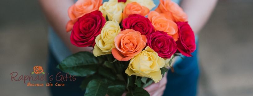 A person holding a colorful bouquet of roses and a Raphael's Gifts logo at the lower left corner